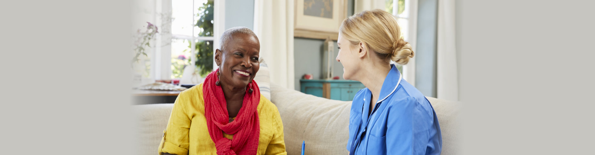 female community nurse visits senior woman at home