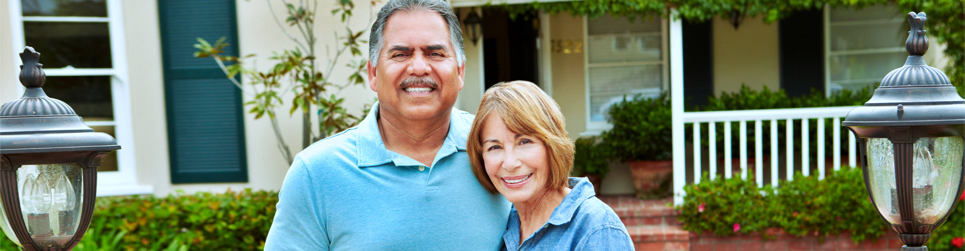 senior couple in front of their house