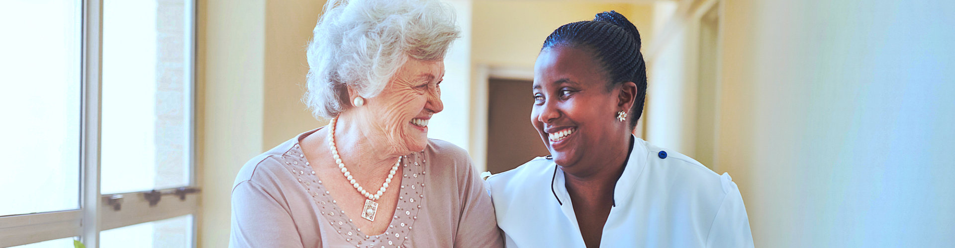 senior woman and a caregiver smiling